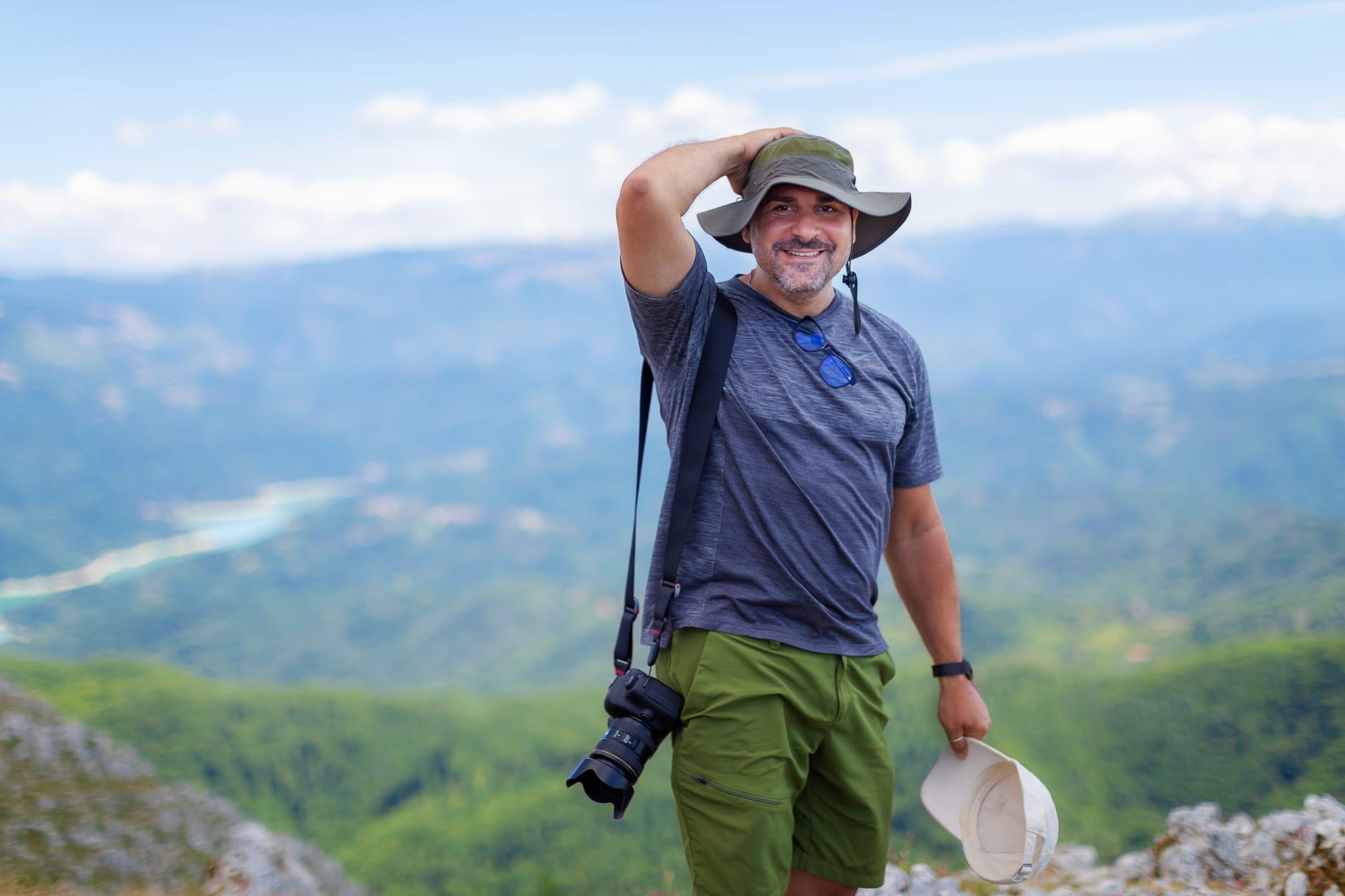 A man in his forties smiling on a mountain hike