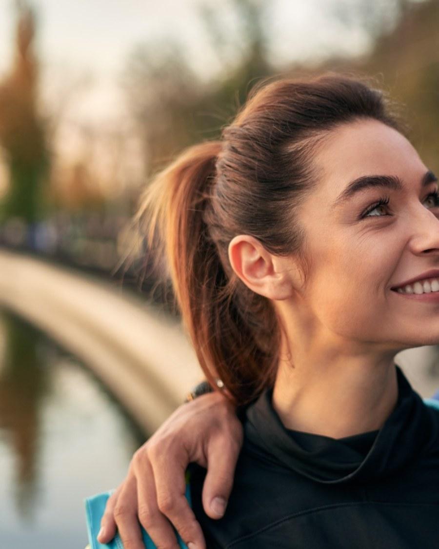 A woman smiling outdoors in warm evening light