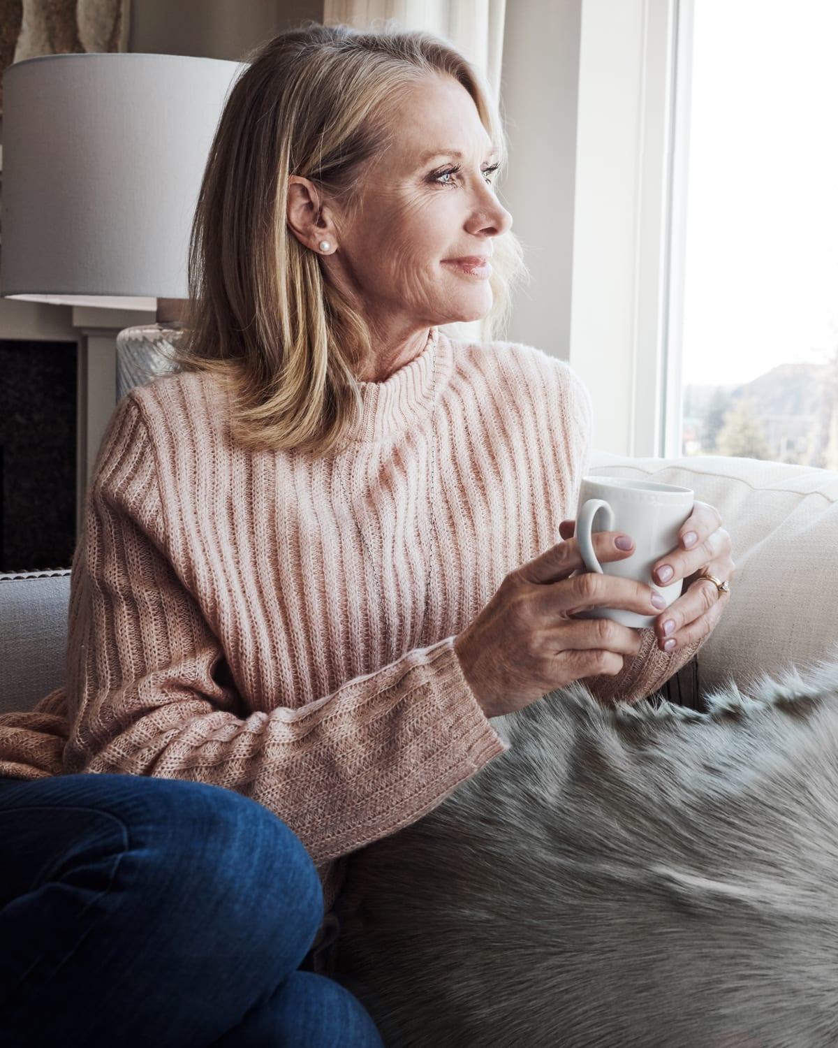 A woman in her sixties with silver hair, smiling warmly