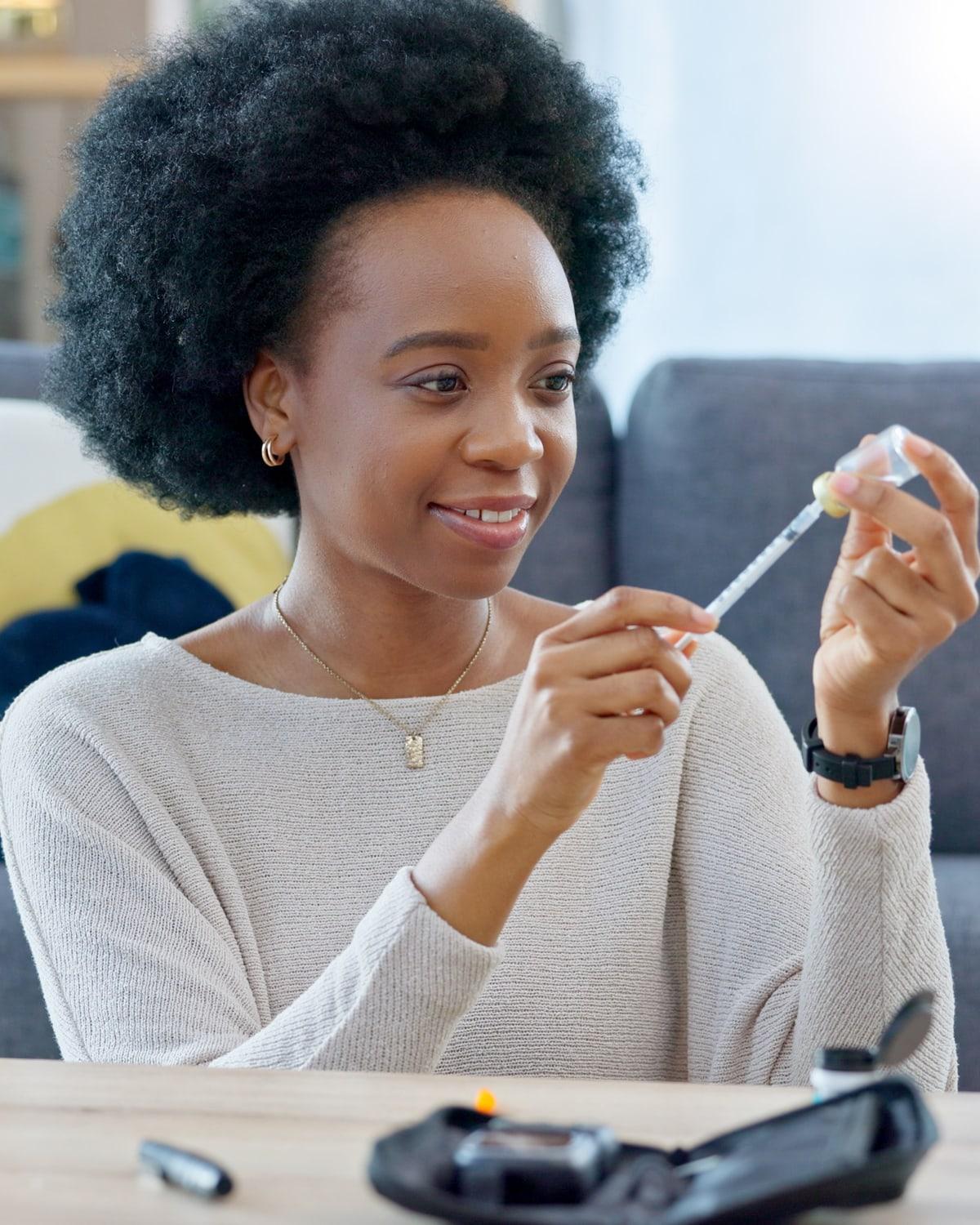A woman at home preparing a weekly injection pen at her kitchen table
